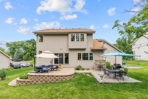 Peaceful backyard w/ oversized paver patio, mature trees, privacy + extensive landscaping