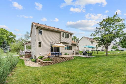 Peaceful backyard w/ oversized paver patio, mature trees, privacy + extensive landscaping