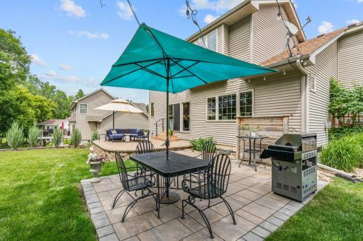 Peaceful backyard w/ oversized paver patio, mature trees, privacy + extensive landscaping