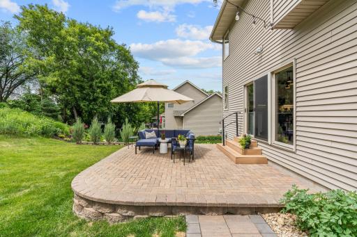 Peaceful backyard w/ oversized paver patio, mature trees, privacy + extensive landscaping