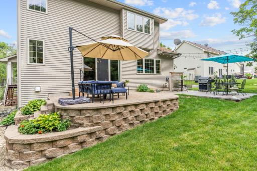 Peaceful backyard w/ oversized paver patio, mature trees, privacy + extensive landscaping