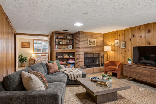 Cozy family room in knotty pine with fireplace (Virtual staging)