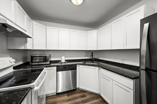 Updated white cabinetry and granite countertops create a bright, timeless kitchen.
