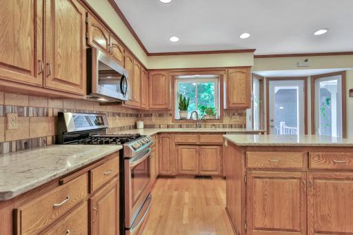 Kitchen features Cambria countertops - center island - stone backsplash - walk out to patio and screened porch area
