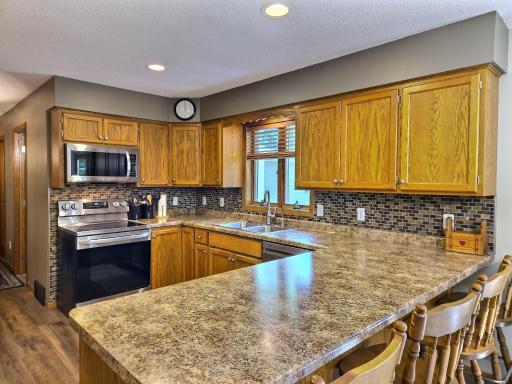 L-shaped countertop with seating in the kitchen. Vinyl plank flooring updated in 2022