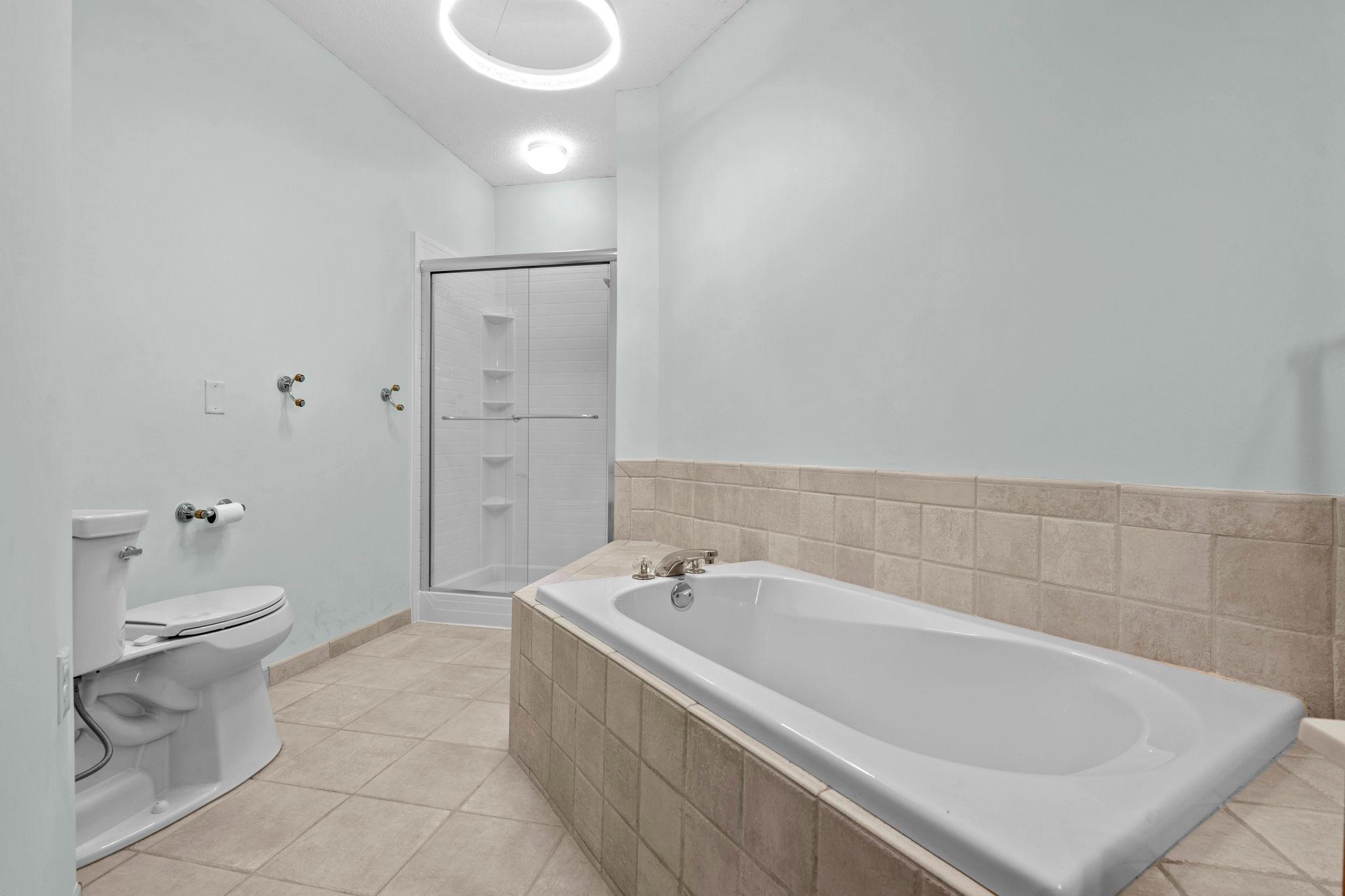 Primary bathroom with beautiful tilework. Large soaking tub and seperate shower.