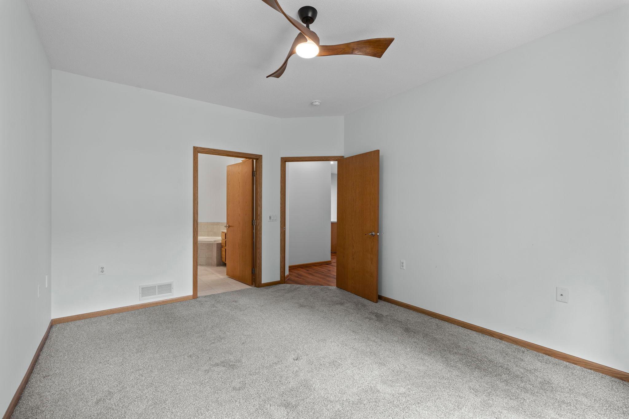 Main level primary bedroom with ensuite bathroom and large closet.