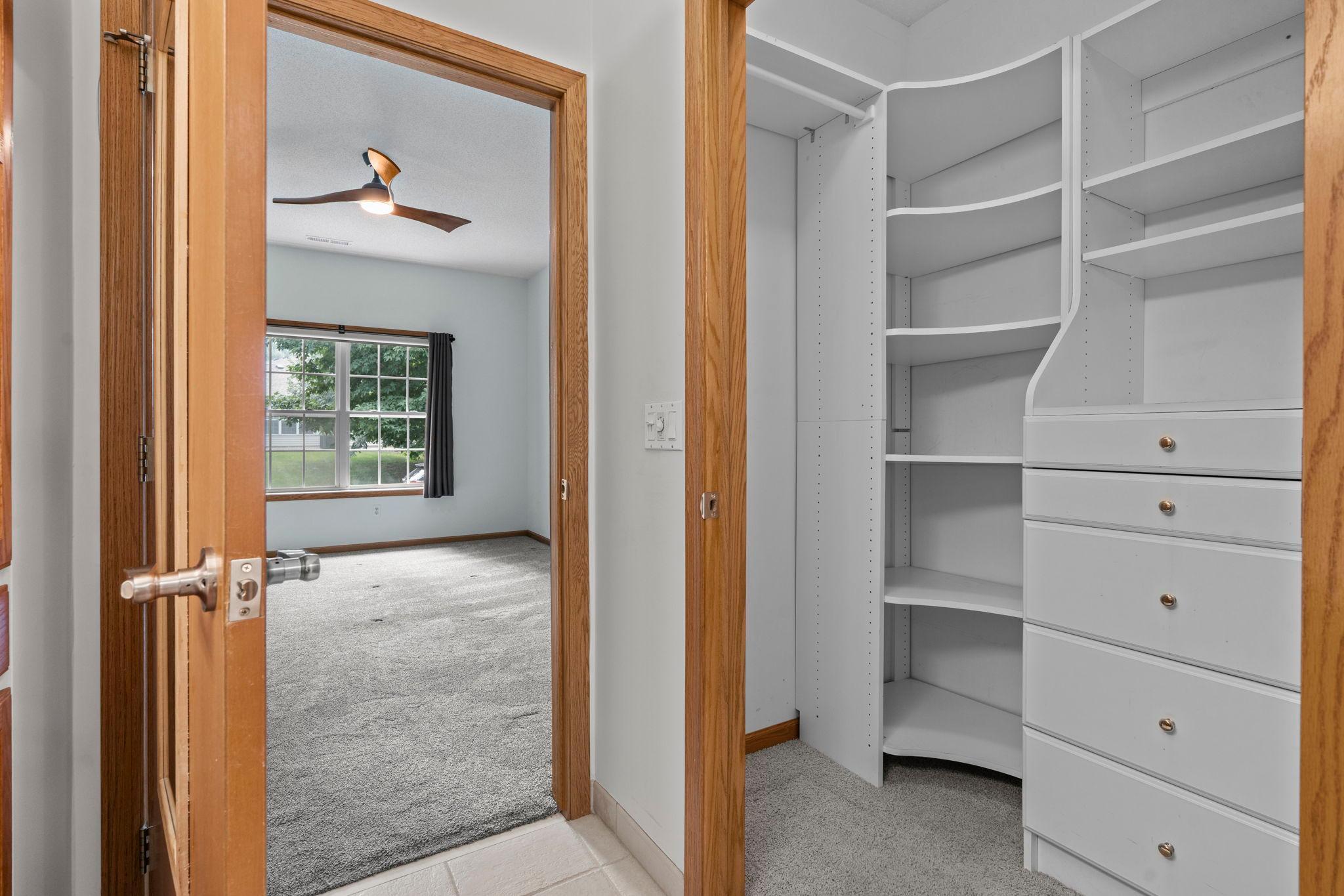 Large primary closet with custom organization, built-ins and drawers.