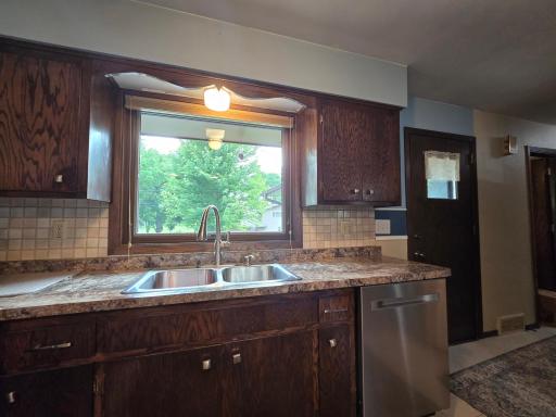 Oak kitchen cabinets with large kitchen sink window with East view of large backyard where you can watch your garden grow! Stainless steel appliances including dishwasher