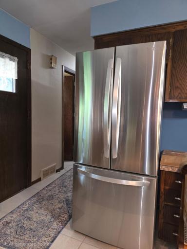 Kitchen back door to a large stone patio, ceramic floor and oversize stainless bottom drawer side by side refrigerator