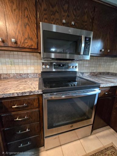 Kitchen with oak cabinets, flat top stainless steel stove oven and appliances with Granite counter tops