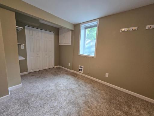 4th bedroom carpeted with egress window and closet with closet system.