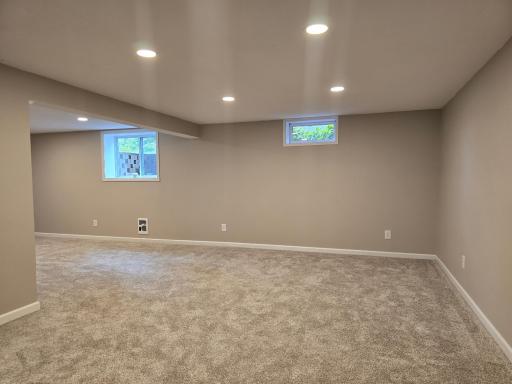 The family room with large egress window and natural lighting...ceiling has recessed lighting feature.