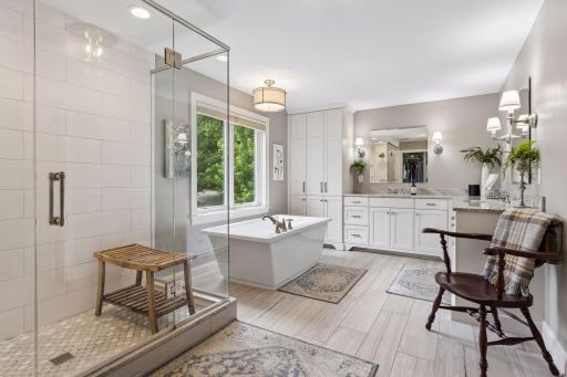 Spa-inspired primary bath features quartzite dual vanities, soaking tub, walk-in shower, and private water closet.