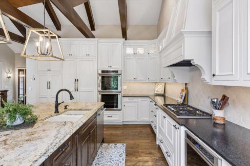 Under-cabinet lighting, beautiful tile backsplash, double ovens, gas cooktop and built-in refrigerator make this kitchen a chefs delight.