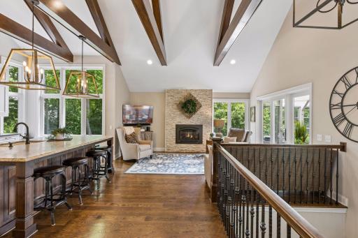 Soaring vaulted ceilings with exposed beams create a dramatic architectural statement, while walls of windows fill the home with natural light.