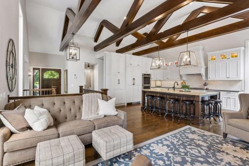 Vaulted ceilings with exposed beams and rich white oak hardwood floors create a warm yet elegant atmosphere.