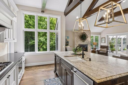 Large kitchen windows look out to nearly an acre of private wooded space with mature trees, shrubs and perennial plantings.
