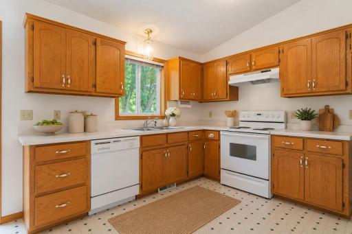 Exceptional cabinet condition highlights this efficient kitchen, offering abundant storage, ample counter space, and a window above the sink that brings in natural light. Photo has been virtually staged.