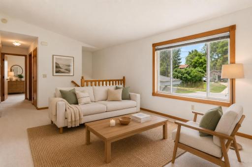 Comfortable living room with abundant natural light and convenient access to the bedrooms and main living areas. Photo has virtually staged.