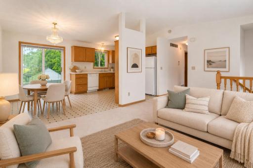 Enjoy an open layout featuring a spacious living room, dining area, and kitchen with views of the backyard. Photo has been virtually staged.