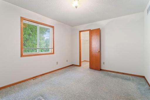 Spacious bedroom with walk in closet is filled with natural light and plenty of room to create a relaxing retreat at the end of the day.