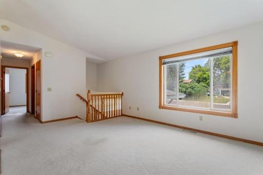 Unstaged view highlighting the spacious living room and large picture window overlooking the front yard and neighborhood.