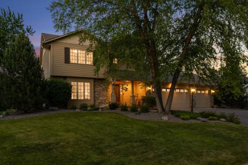Beautifully maintained two-story home nestled among mature trees and professional landscaping.