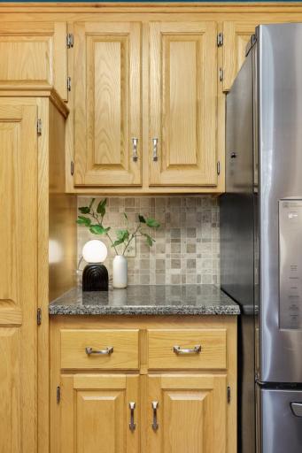 Solid wood cabinetry, granite surfaces, and updated appliances create a timeless kitchen design.