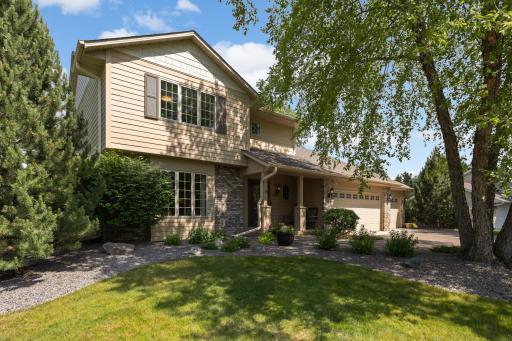 Professional landscaping, mature trees, and a spacious three-car garage enhance curb appeal.
