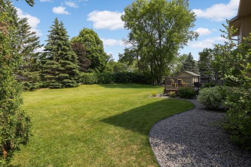 Expansive, park-like backyard surrounded by mature trees, offering privacy and room to play, garden, or relax.