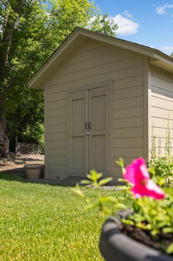 Backyard storage shed provides convenient space for lawn equipment, tools, and seasonal items.