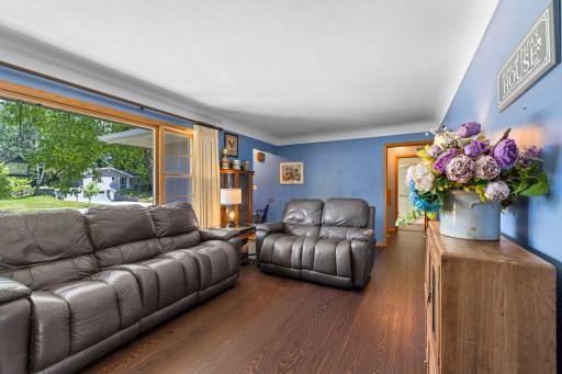 Bright living area featuring multiple windows, warm hardwood floors, and rich wood cabinetry.
