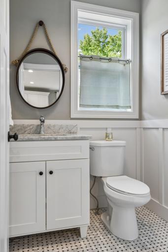 Convenient main floor powder room with marble vanity and modern updates.