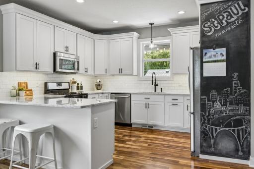 Bright and functional kitchen with marble countertops, stainless steel appliances, and ample workspace.