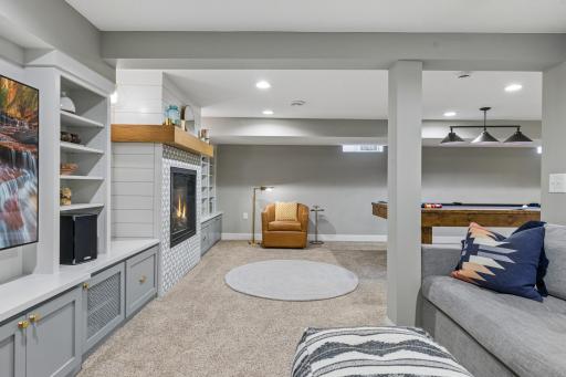 Lower level family room offers additional living space with fireplace and custom built-ins.