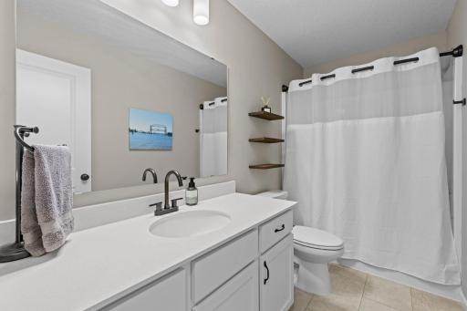 Full bathroom freshly painted with new shelving and quartz countertops. Energy efficient faucets and toilet & shower head. LVT flooring.