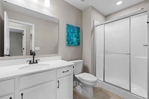 3/4 Bathroom on lower level with Quartz Countertops, Energy Efficient Toilet & Shower Head, and LVT Flooring