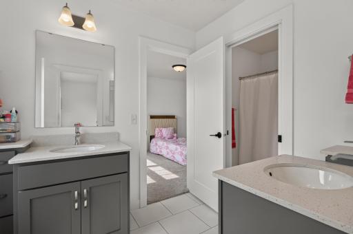 Perfect for siblings or guests, the Jack and Jill layout features individual sink areas and a centrally shared tub and shower space.