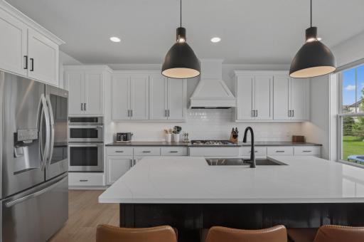 Designed to impress, this stunning kitchen showcases crisp white cabinetry, sleek quartz countertops, premium stainless steel appliances, and an oversized island that's perfect for gathering and entertaining.
