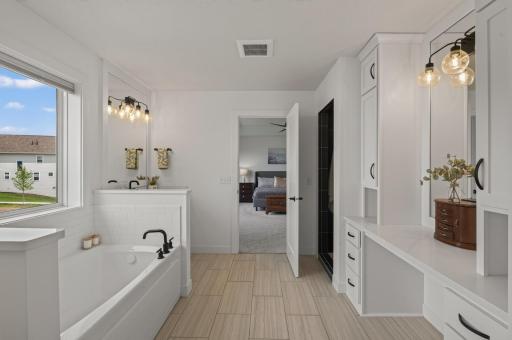A spa-inspired primary bathroom blends everyday comfort with thoughtful design, featuring a soaking tub, generous vanity space, built-in storage, and a seamless connection to the primary suite.