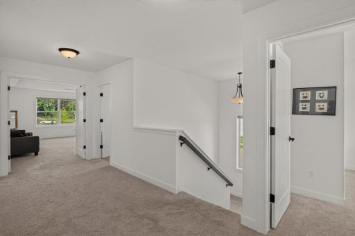 The spacious upper level landing area creates an inviting transition between the bedrooms, offering an open, airy feel and easy access to the home's private living spaces.