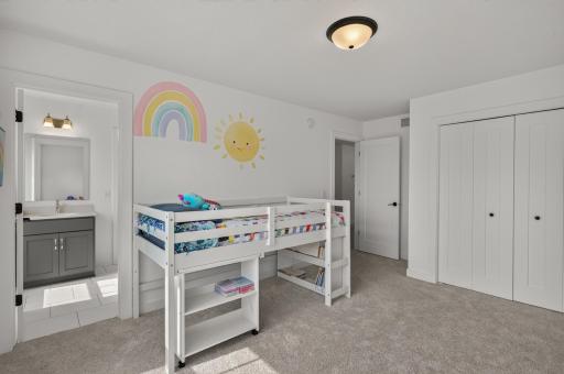 This cheerful first bedroom on the upper level offers generous proportions, a large closet, and direct access to a Jack and Jill bathroom.