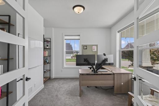 French doors open to a bright front office, creating a quiet, professional space with abundant sunlight--perfect for remote work, client meetings, or managing household tasks. This room would also make a great playroom or private reading retreat.