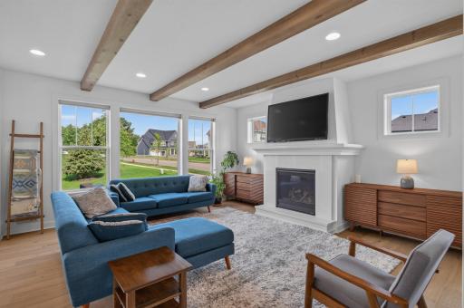 Warm wood ceiling beams, a striking gas fireplace, and walls of windows create an inviting gathering space that's equal parts sophisticated and comfortable.