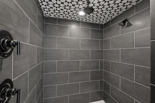 This close-up shot of the primary shower highlights the multiple showerheads and dramatic floor-to-ceiling tile. This is the ultimate resort inspired retreat.