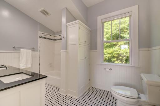 Upper level hallway bathroom has the continuity of materials and design seen in the other two bathrooms.