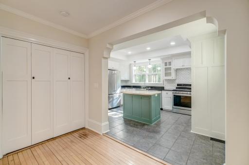 The brand new kitchen flows into the main level rooms. The laundry center is tucked in behind the double doors.