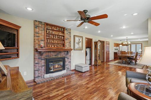 Living room features a gas fireplace with a wood mantel and brick wall.