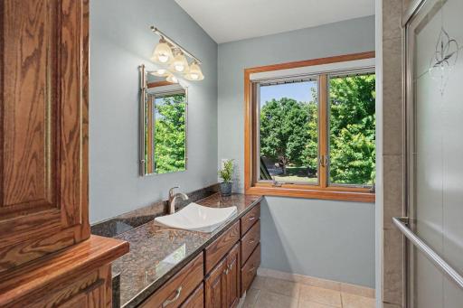 Ensuite bathroom with granite counter and tile floors and shower.